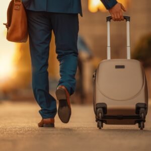 شاب يجر حقيبة سفر في مطار أثناء السفر إلى ألمانيا للدراسة أو الأوسبيلدونج وتعلم اللغة الألمانية